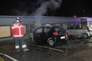 Brændende bil stod tæt op af bygning