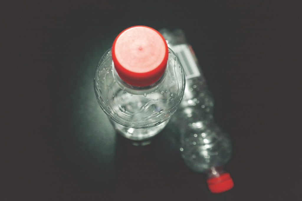 two clear plastic bottles on black surface