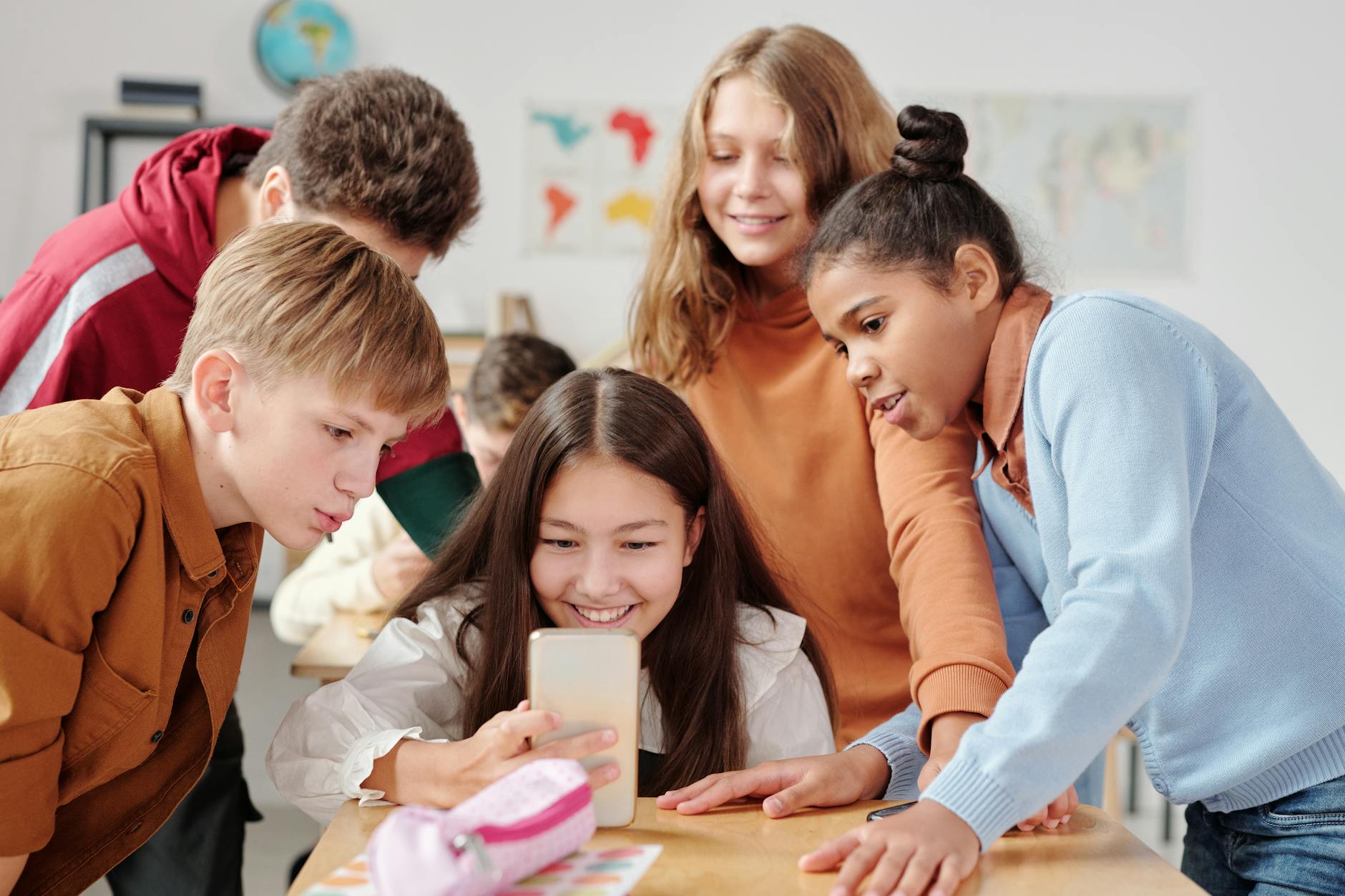 a boys and girls watching on the smartphone together